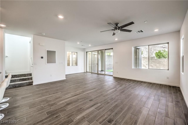 unfurnished living room with baseboards, a ceiling fan, dark wood finished floors, and visible vents