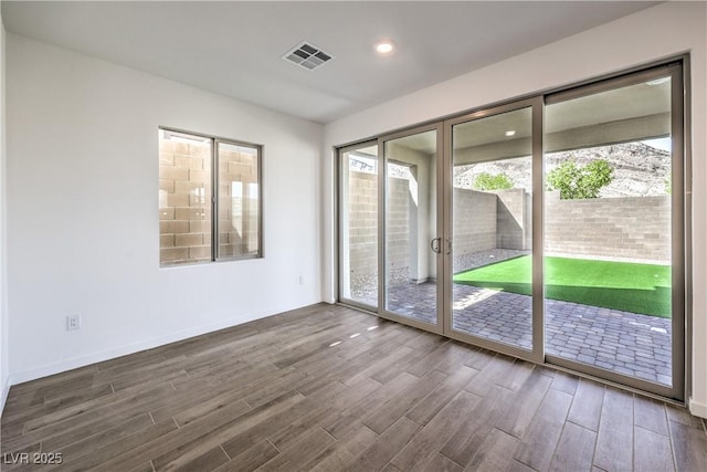 spare room with visible vents, recessed lighting, and dark wood-style flooring