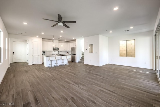 unfurnished living room featuring recessed lighting, ceiling fan, visible vents, and dark wood-style floors