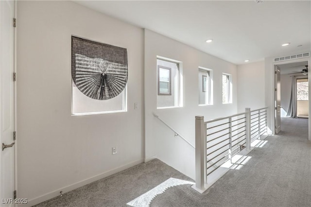 stairway featuring baseboards, a wealth of natural light, carpet, and visible vents