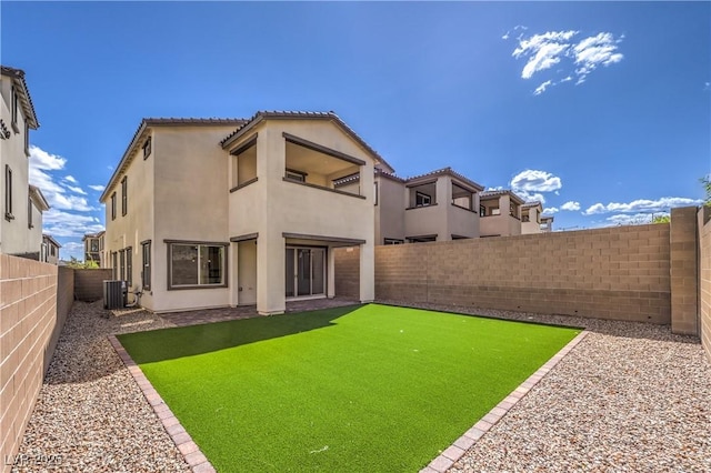 rear view of property with a fenced backyard, stucco siding, a balcony, and cooling unit