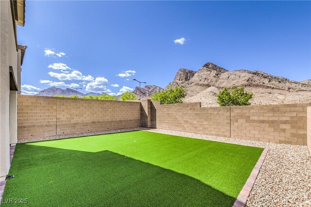 view of yard featuring a fenced backyard and a mountain view