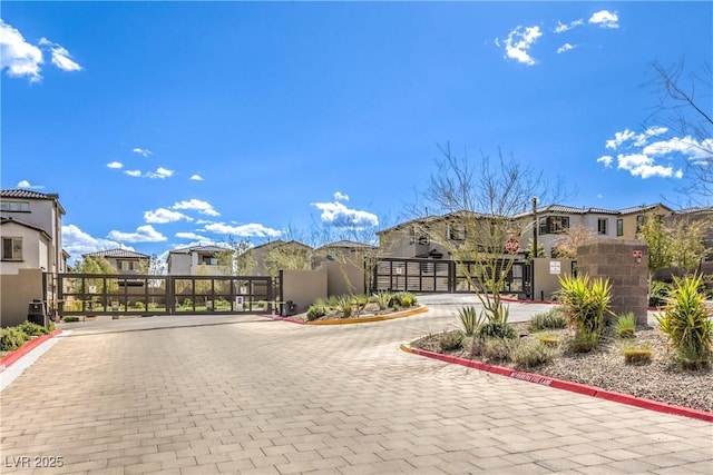 view of street featuring a residential view, a gate, and curbs