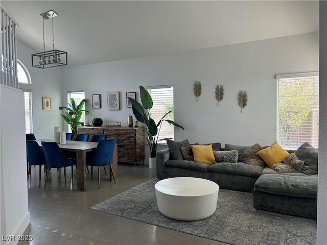 living room with concrete floors, a wealth of natural light, and a chandelier