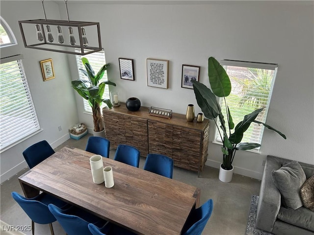 dining room with a chandelier and baseboards