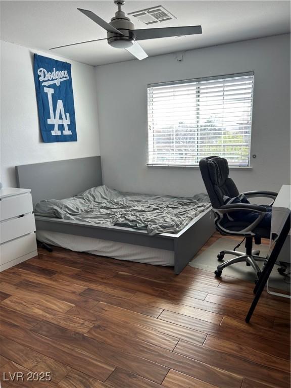 bedroom with visible vents, ceiling fan, and wood finished floors
