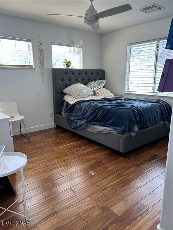 bedroom with wood-type flooring, visible vents, baseboards, and a ceiling fan