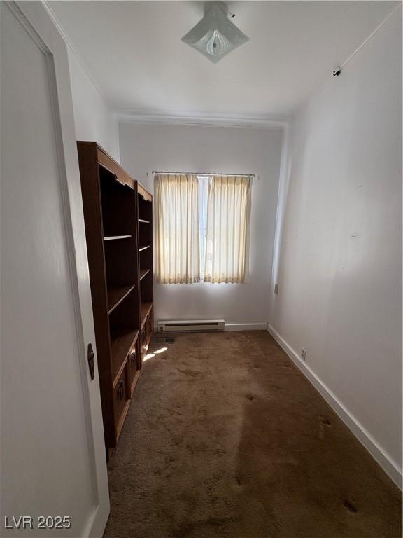 interior space with a baseboard heating unit, baseboards, and carpet floors