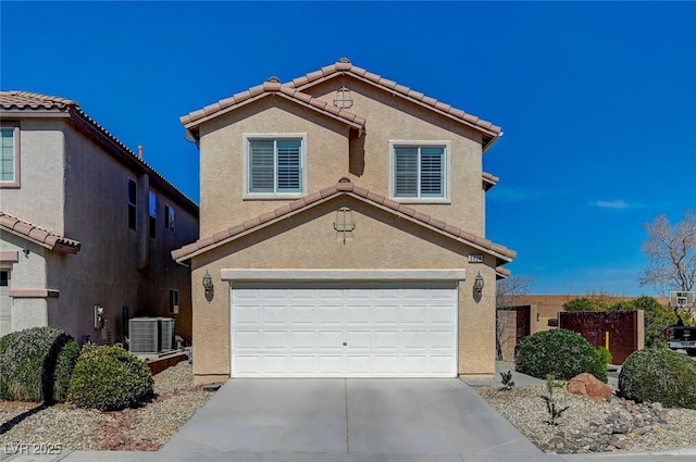 traditional-style house with a tile roof, an attached garage, driveway, and stucco siding