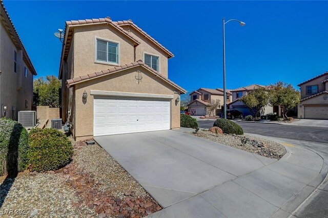view of front of home with concrete driveway, central air condition unit, stucco siding, an attached garage, and a tiled roof
