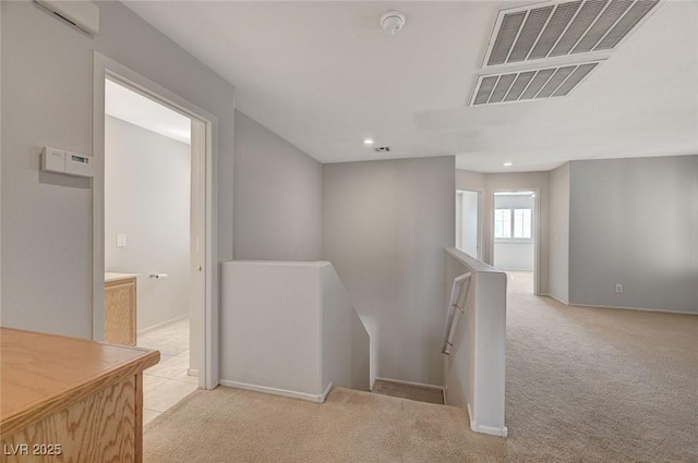hall featuring recessed lighting, an upstairs landing, visible vents, and light colored carpet