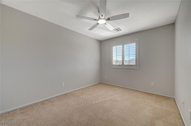 spare room with visible vents, light colored carpet, baseboards, and ceiling fan