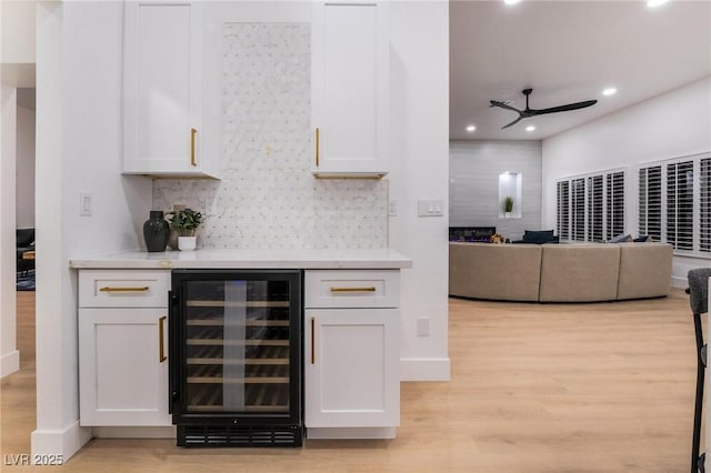 bar with ceiling fan, tasteful backsplash, light wood-type flooring, recessed lighting, and wine cooler