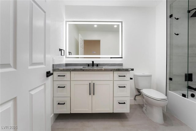 full bathroom with toilet, vanity, enclosed tub / shower combo, and baseboards