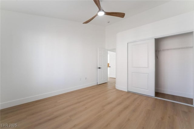 unfurnished bedroom featuring ceiling fan, a closet, light wood finished floors, and baseboards