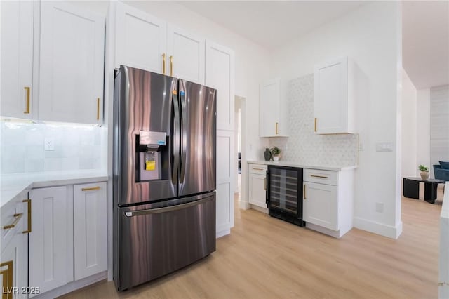 kitchen featuring white cabinets, stainless steel fridge, light wood-type flooring, backsplash, and beverage cooler