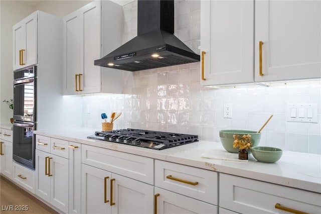 kitchen with white cabinets, exhaust hood, gas stovetop, double oven, and backsplash