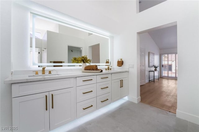 full bath featuring double vanity, baseboards, and a sink