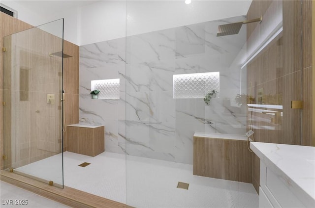 full bathroom featuring vanity and a marble finish shower