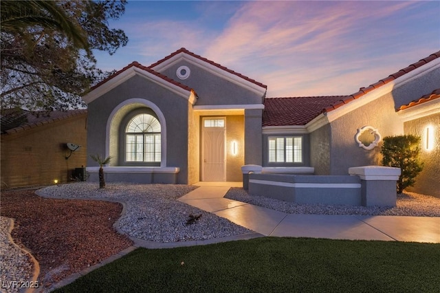 view of exterior entry featuring a tile roof and stucco siding