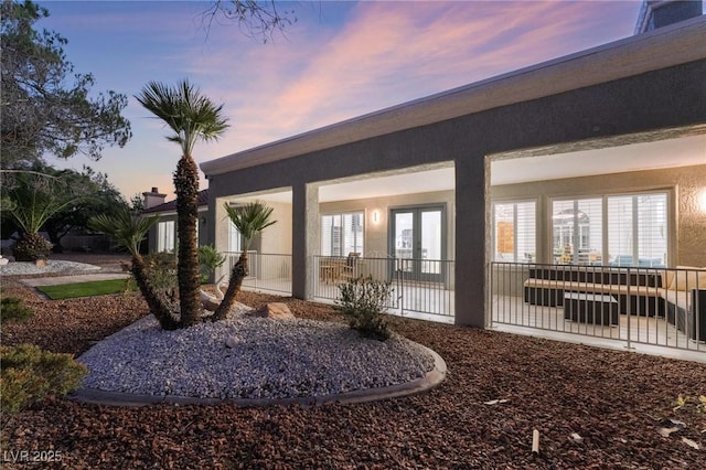 view of exterior entry with a patio and stucco siding
