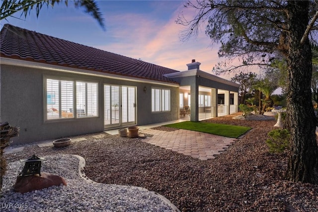 back of house featuring a patio area, stucco siding, french doors, and a tile roof
