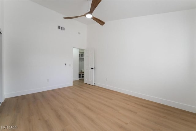 spare room featuring light wood-style flooring, baseboards, and ceiling fan
