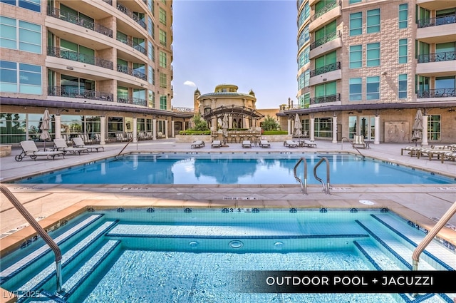 community pool with a patio area and a hot tub