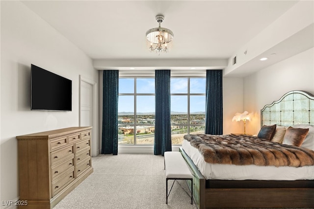 bedroom featuring light carpet, visible vents, and an inviting chandelier