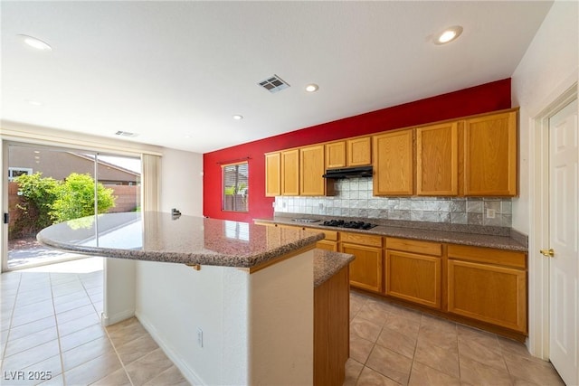 853 Ashford Way, Henderson, NV 89015 - kitchen featuring light tile patterned floors, a center island, backsplash, light stone countertops, and visible vents
