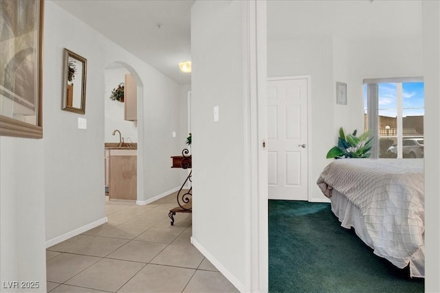 6480 Annie Oakley Dr Unit 511, Las Vegas, NV 89120 - bedroom featuring arched walkways, light tile patterned floors, baseboards, and a sink