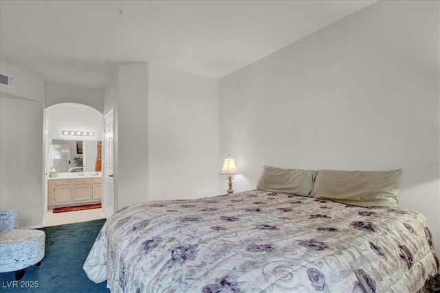 6480 Annie Oakley Dr Unit 511, Las Vegas, NV 89120 - tiled bedroom featuring visible vents, arched walkways, and ensuite bath