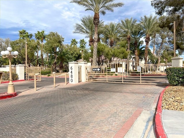 6480 Annie Oakley Dr Unit 511, Las Vegas, NV 89120 - view of road featuring street lights, a gated entry, curbs, and a gate