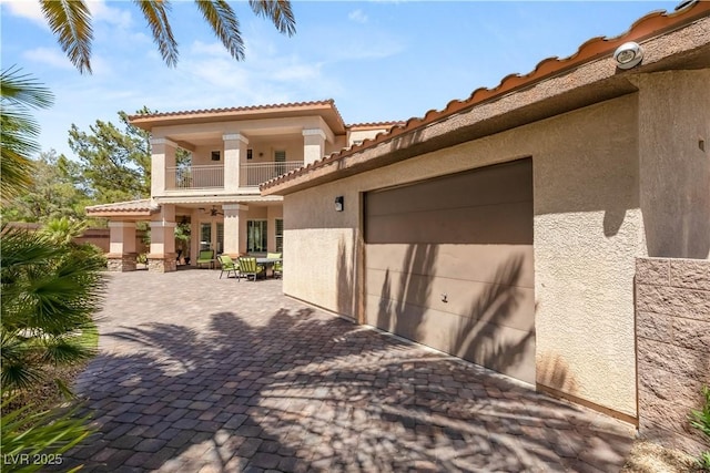 2285 Villefort Ct, Las Vegas, NV 89117 - view of front facade with a balcony, stucco siding, a tiled roof, and a garage