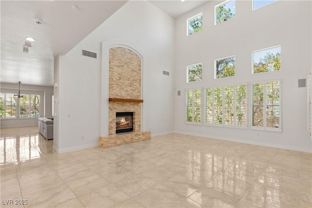 2285 Villefort Ct, Las Vegas, NV 89117 - unfurnished living room featuring a high ceiling, a glass covered fireplace, baseboards, and a chandelier