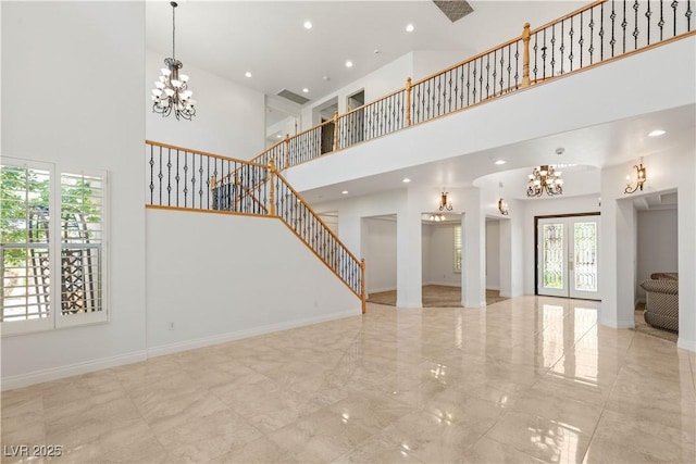 2285 Villefort Ct, Las Vegas, NV 89117 - unfurnished living room with a towering ceiling, a chandelier, stairs, marble tiled floors, and baseboards