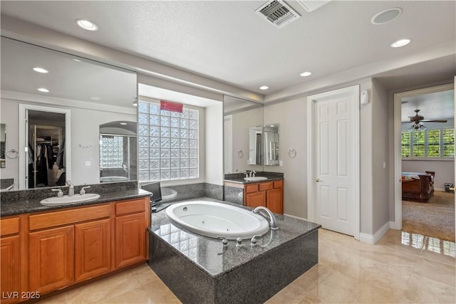 2285 Villefort Ct, Las Vegas, NV 89117 - bathroom featuring recessed lighting, a tub with jets, two vanities, and ceiling fan