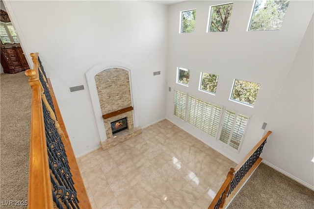 2285 Villefort Ct, Las Vegas, NV 89117 - unfurnished living room featuring a towering ceiling, a fireplace, baseboards, and carpet