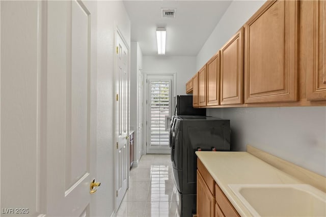 2285 Villefort Ct, Las Vegas, NV 89117 - laundry area with washer and clothes dryer, light tile patterned floors, and cabinet space