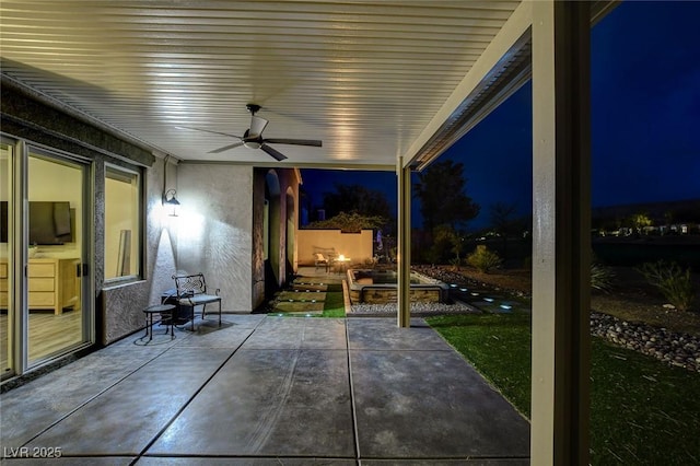 patio at night featuring a ceiling fan