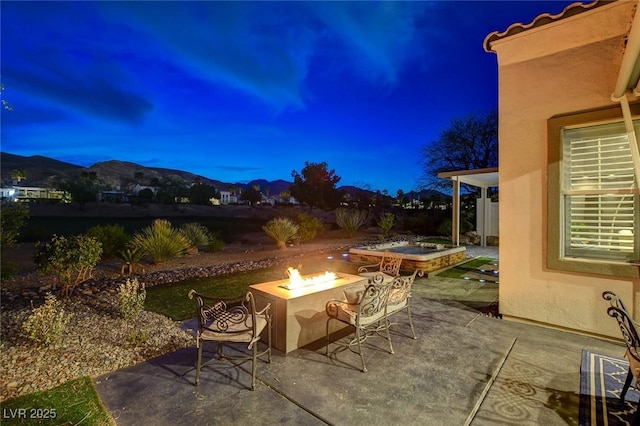 patio at twilight featuring an outdoor fire pit