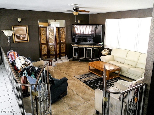 living area featuring tile patterned floors, ceiling fan, and visible vents