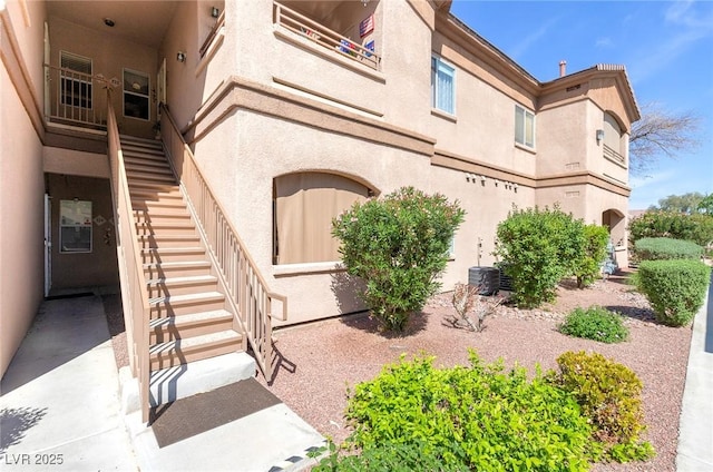 property entrance featuring central air condition unit and stucco siding