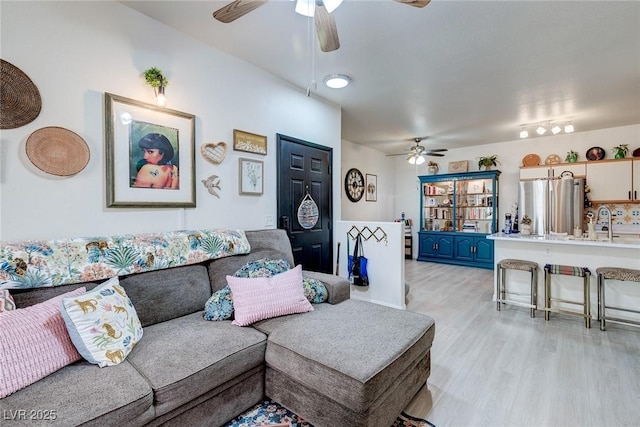 living area featuring light wood-type flooring and ceiling fan