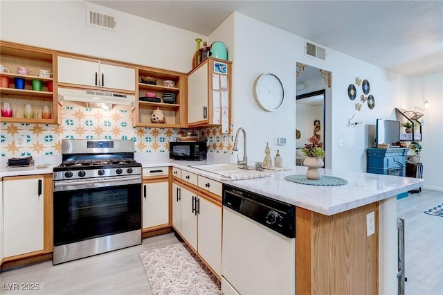 kitchen with under cabinet range hood, dishwasher, visible vents, open shelves, and stainless steel range with gas stovetop