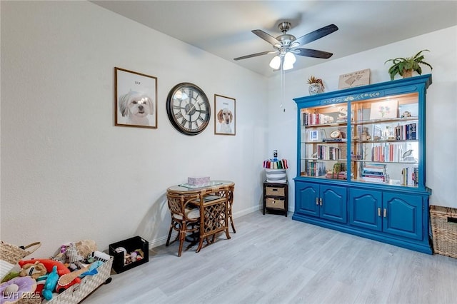 playroom featuring baseboards, ceiling fan, and light wood-type flooring