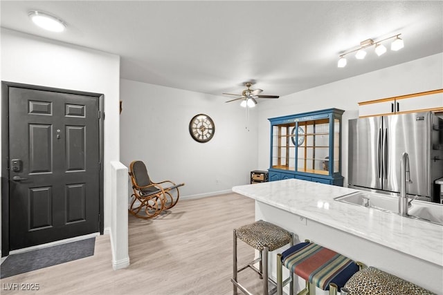 5751 Hacienda Ave Unit 135, Las Vegas, NV 89122 - kitchen with freestanding refrigerator, a sink, baseboards, ceiling fan, and a breakfast bar area