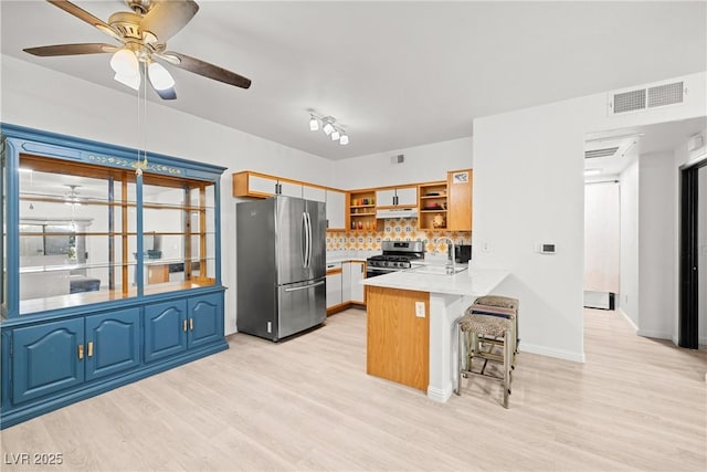 5751 Hacienda Ave Unit 135, Las Vegas, NV 89122 - kitchen with stainless steel appliances, a sink, a ceiling fan, a peninsula, and open shelves