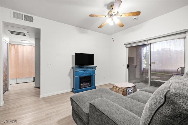 5751 Hacienda Ave Unit 135, Las Vegas, NV 89122 - living room featuring light wood-style flooring, baseboards, a ceiling fan, and a fireplace