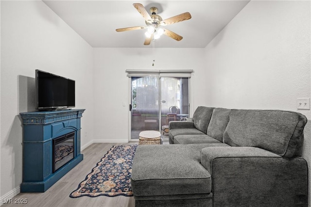 5751 Hacienda Ave Unit 135, Las Vegas, NV 89122 - living room featuring light wood finished floors, ceiling fan, baseboards, and a glass covered fireplace